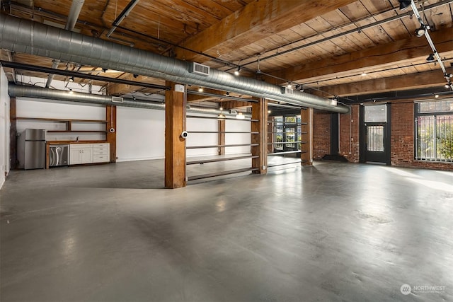 garage featuring wooden ceiling and stainless steel refrigerator