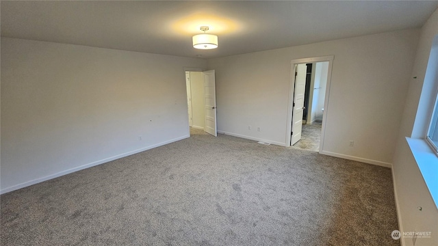 empty room with baseboards and carpet flooring