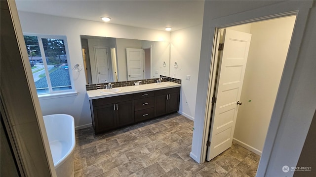 bathroom featuring vanity, tasteful backsplash, and a bathing tub