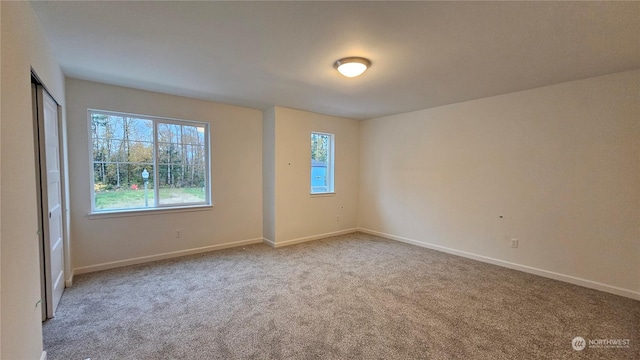 empty room featuring carpet floors and baseboards