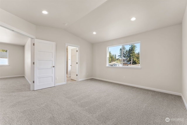 unfurnished bedroom featuring lofted ceiling and light carpet