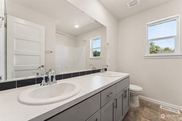 bathroom featuring walk in shower, vanity, and toilet