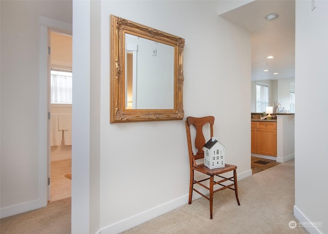 hallway featuring light colored carpet and plenty of natural light