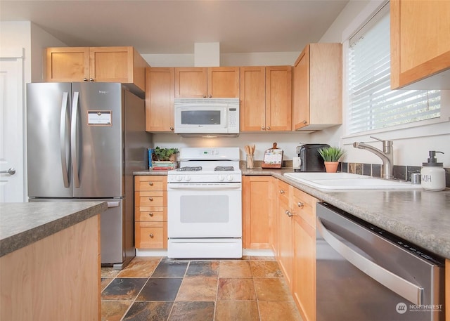 kitchen with appliances with stainless steel finishes, light brown cabinets, and sink