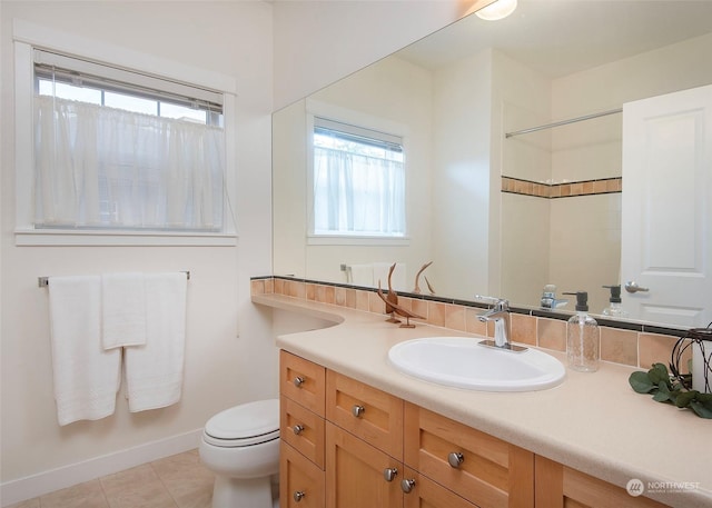 bathroom with tile patterned floors, vanity, toilet, and walk in shower