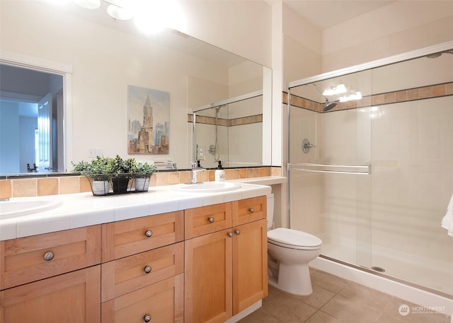 bathroom with tile patterned floors, walk in shower, vanity, and toilet