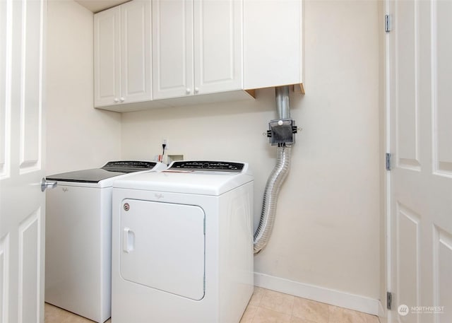 laundry area with cabinets, light tile patterned floors, and washing machine and clothes dryer