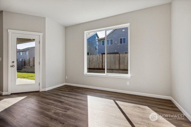 spare room featuring wood finished floors and baseboards