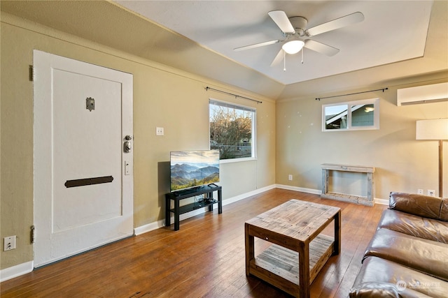 living room with hardwood / wood-style flooring, ceiling fan, vaulted ceiling, and a wall mounted air conditioner