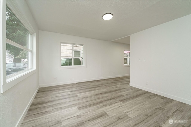 empty room featuring a textured ceiling and light wood-type flooring