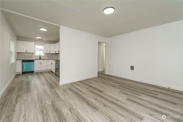 unfurnished living room with a textured ceiling, light hardwood / wood-style floors, and sink