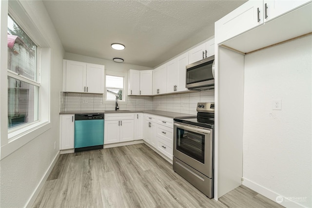 kitchen with stainless steel appliances, backsplash, white cabinets, and sink