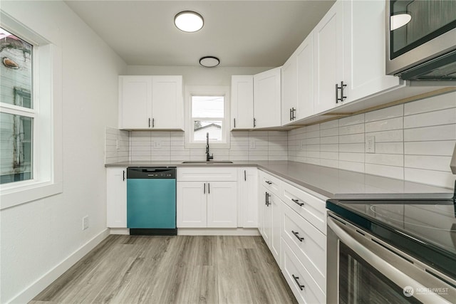 kitchen featuring appliances with stainless steel finishes, light hardwood / wood-style floors, white cabinets, and sink