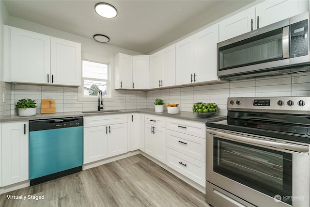 kitchen featuring light hardwood / wood-style floors, sink, white cabinets, and appliances with stainless steel finishes