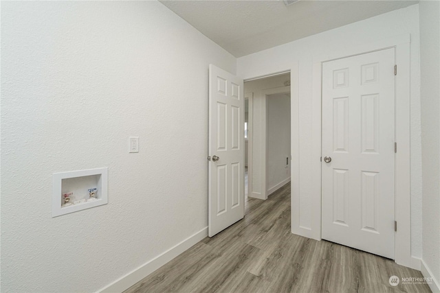 laundry room with washer hookup and light hardwood / wood-style flooring