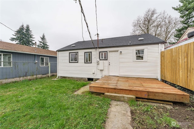 rear view of property with a wooden deck and a yard