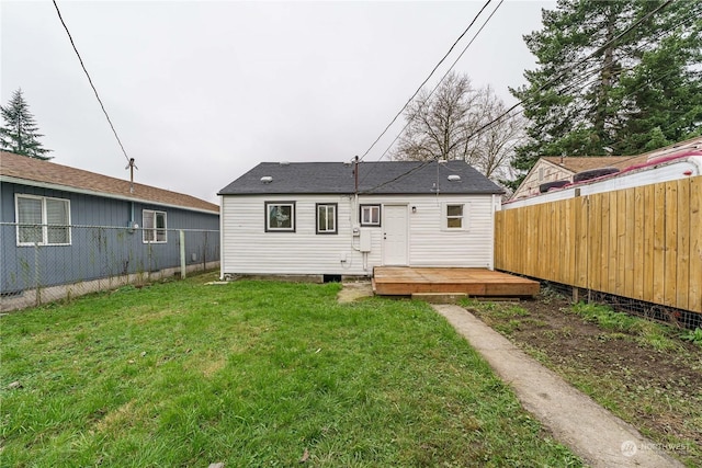 rear view of property featuring a deck and a lawn