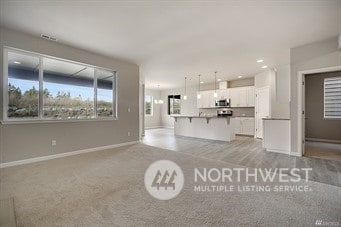 unfurnished living room featuring light carpet