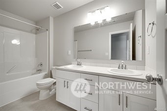 full bathroom with vanity,  shower combination, and toilet