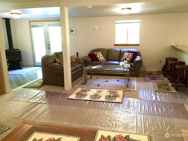 living room featuring plenty of natural light, french doors, and a wood stove