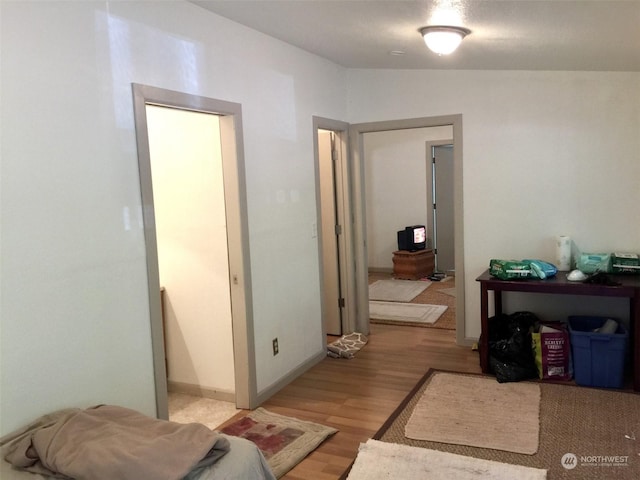 corridor featuring vaulted ceiling and light hardwood / wood-style flooring