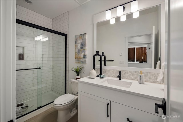 bathroom with toilet, backsplash, tile patterned flooring, an enclosed shower, and vanity