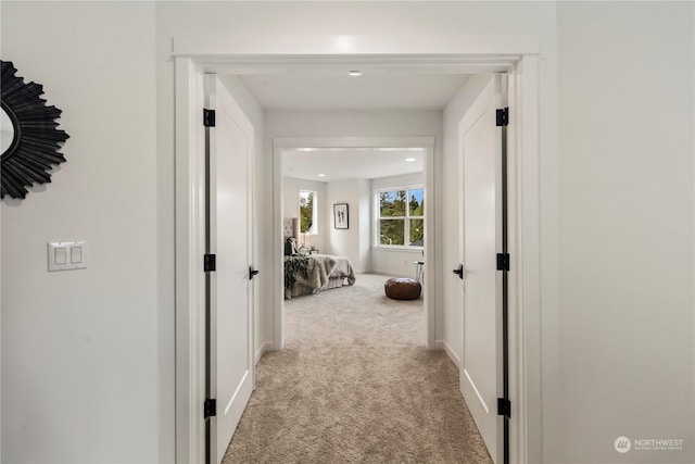 hallway featuring light colored carpet