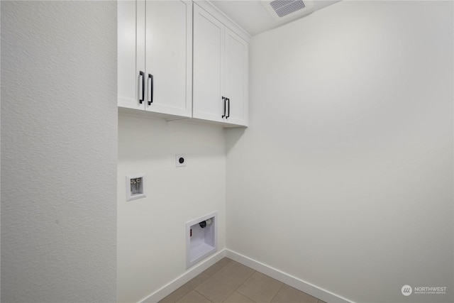 clothes washing area featuring hookup for a washing machine, cabinets, light tile patterned floors, and electric dryer hookup