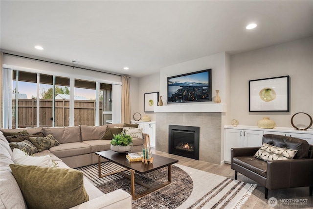 living area featuring light wood-type flooring, a fireplace, and recessed lighting