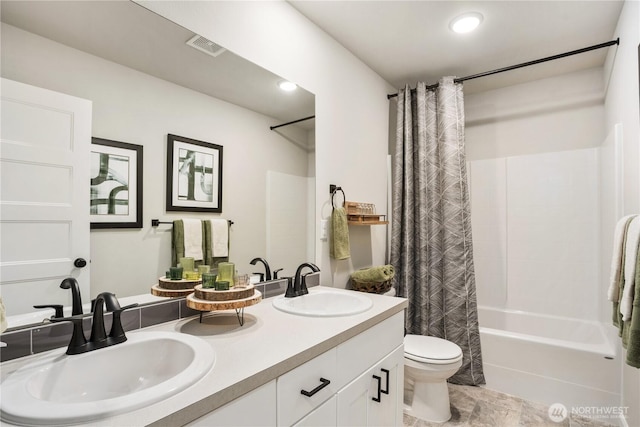 bathroom featuring shower / bath combination with curtain, double vanity, a sink, and toilet