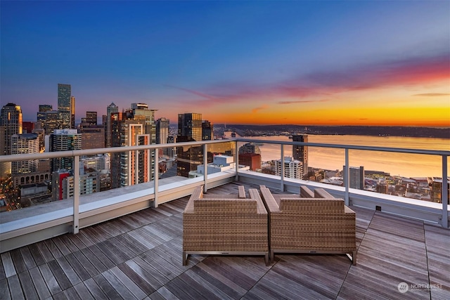 deck at dusk featuring a water view