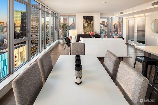 dining area featuring expansive windows and dark hardwood / wood-style flooring