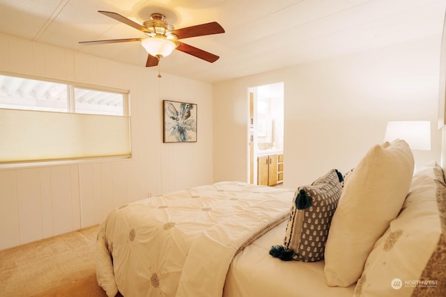 bedroom featuring carpet floors, ceiling fan, and ensuite bath