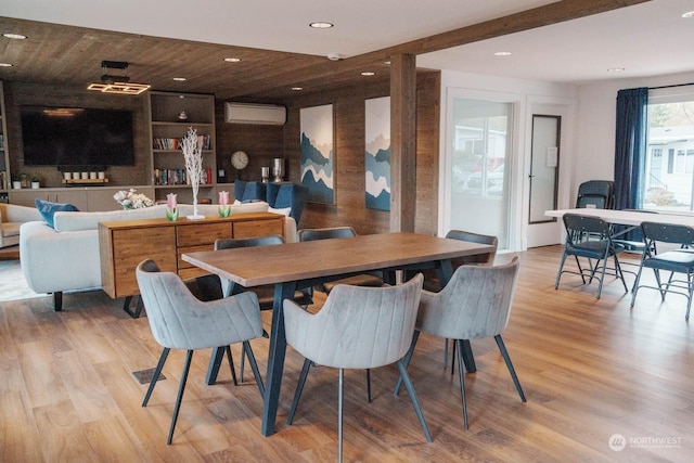 dining room featuring a wall mounted air conditioner, wood ceiling, light hardwood / wood-style flooring, and built in features