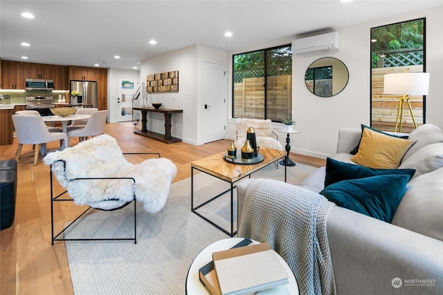 living room with a wall unit AC and light hardwood / wood-style floors