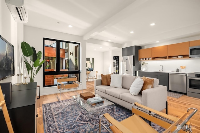 living room with beam ceiling, sink, light hardwood / wood-style flooring, and a wall unit AC