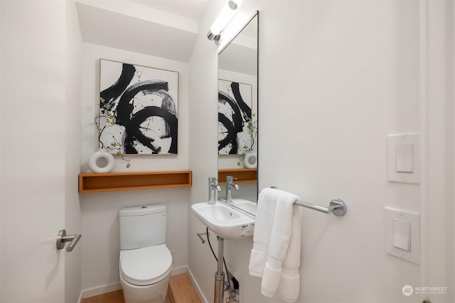 bathroom with hardwood / wood-style flooring and toilet