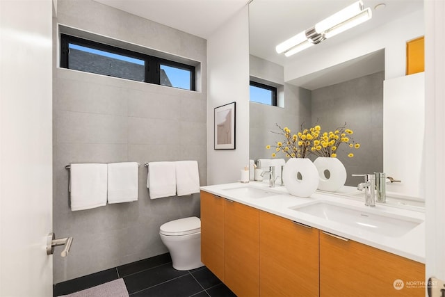 bathroom with toilet, vanity, and tile patterned flooring