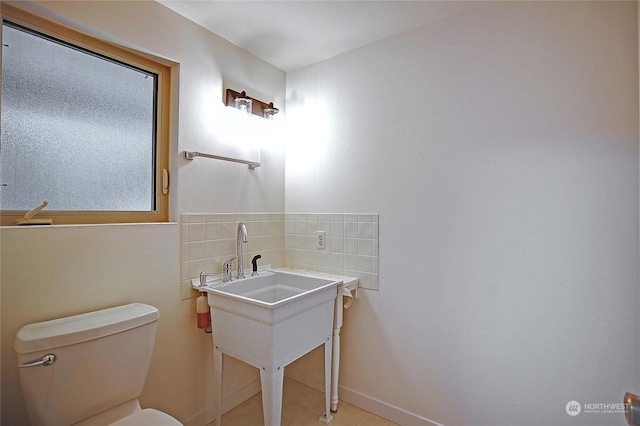 bathroom with tasteful backsplash, tile patterned flooring, and toilet