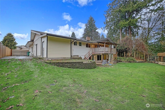 back of property featuring a wooden deck and a lawn