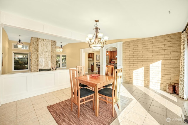 tiled dining area with vaulted ceiling and a notable chandelier