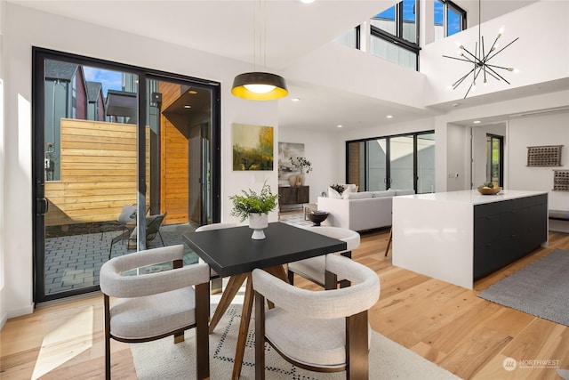 dining area with light hardwood / wood-style flooring and a notable chandelier