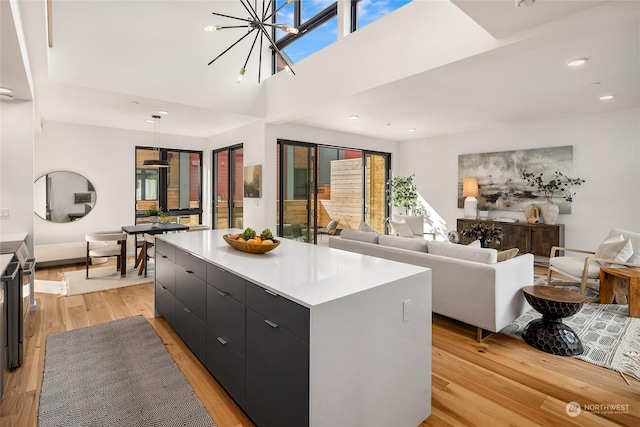 kitchen with a chandelier, light hardwood / wood-style flooring, a large island, and decorative light fixtures