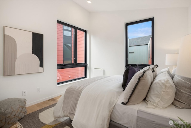 bedroom with vaulted ceiling and hardwood / wood-style floors