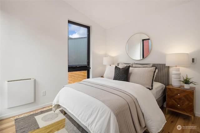 bedroom featuring vaulted ceiling and wood-type flooring