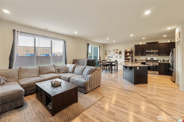 living room with sink and light hardwood / wood-style flooring