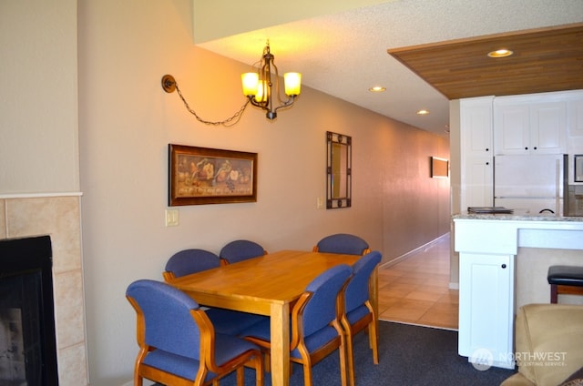 dining area with dark tile patterned floors and a chandelier