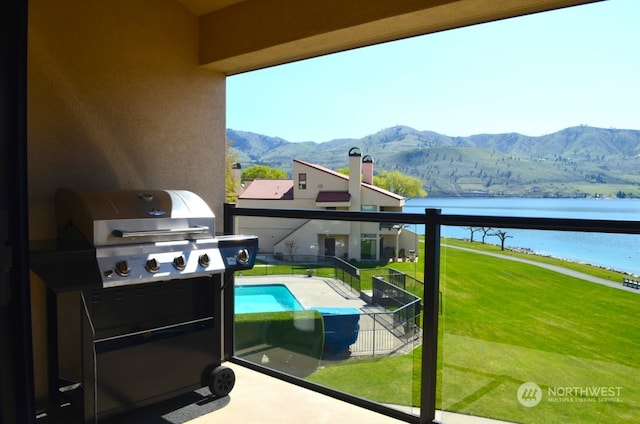 exterior space with a water and mountain view and a grill