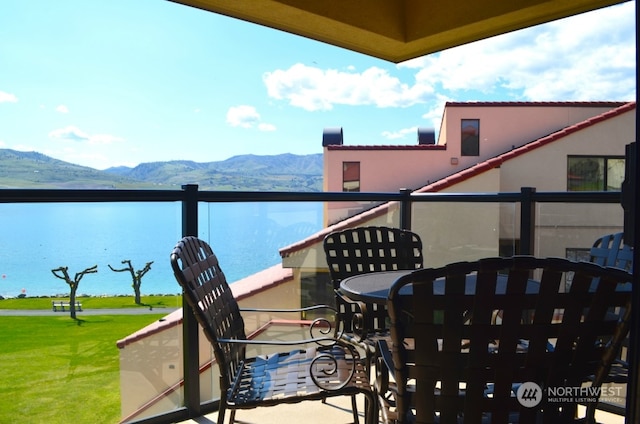 balcony featuring a water and mountain view