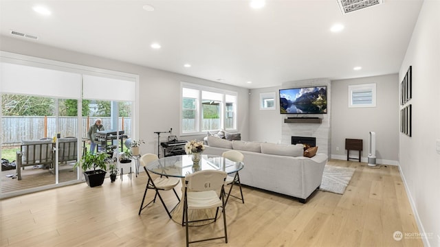 living room with light hardwood / wood-style flooring and a premium fireplace